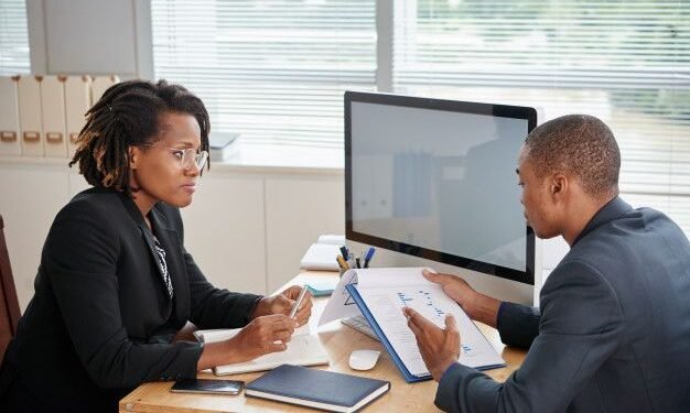 Afro-american man in suit holding documents and talking to female boss _ Free Photo